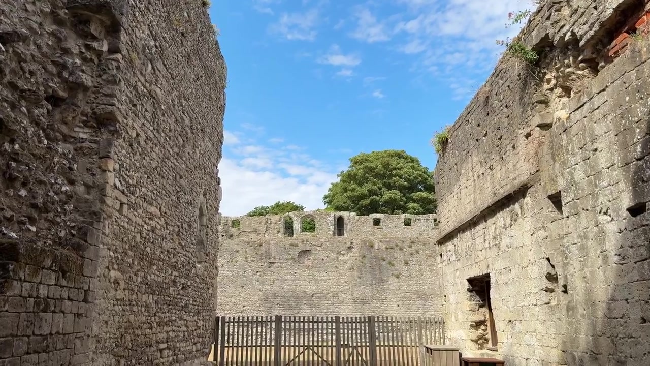 Camminando attraverso l'arco in pietra del Castello di Portchester a Fareham, Inghilterra