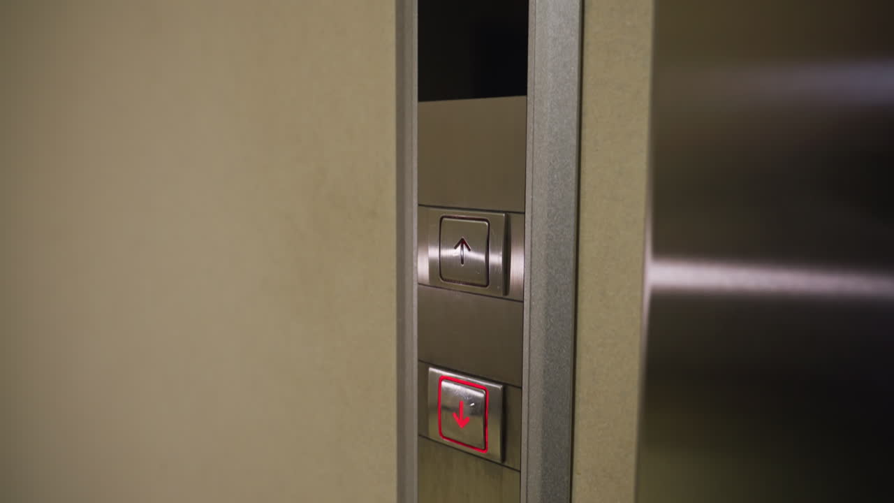 Close-up shot of elevator control panel with upward and downward arrows, illuminated red buttons, modern elevator system, business building, corporate setting, elevator button interface