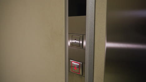 close-up shot of elevator control panel with upward and downward arrows, illuminated red buttons, modern elevator system, business building, corporate setting, elevator button interface