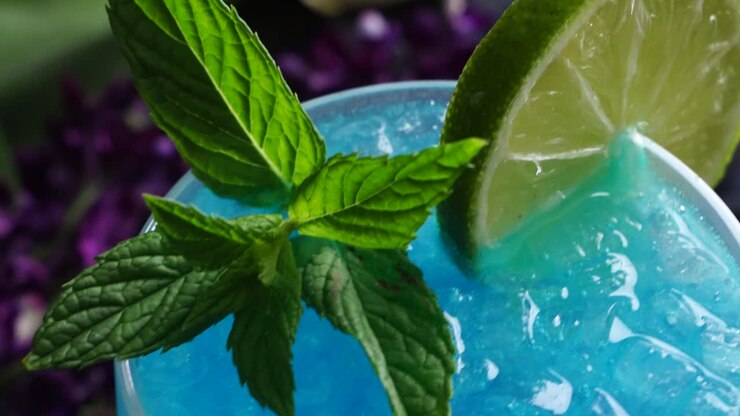 Vibrant cocktail with a striking blue hue from blue curacao, mixed with the zesty of lime juice. Vodka adds a smooth, bold finish, garnished with a lime wheel and fresh mint for a refreshing twist.