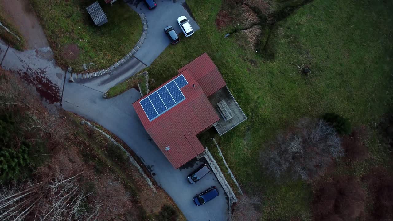 Stort hus med rødt tag i Gérardmer, Frankrig, filmet af en drone der roterer og flyver opad
