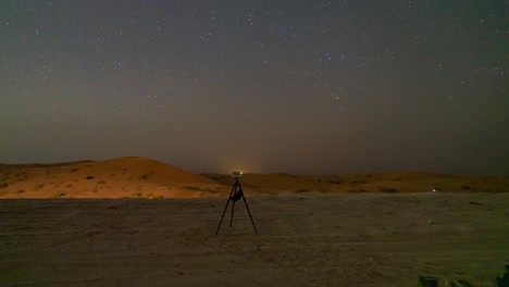 a star gazing party in the al qua'a desert of abu dhabi landscape under a starlit sky, with people observing the rising milky way core with a smart telescope, star tracker, and cameras - time lapse