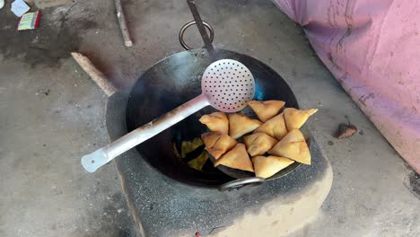 top shot di samosa fritto in olio caldo nel dhaba locale in stile bihari in una stufa tradizionale di terra