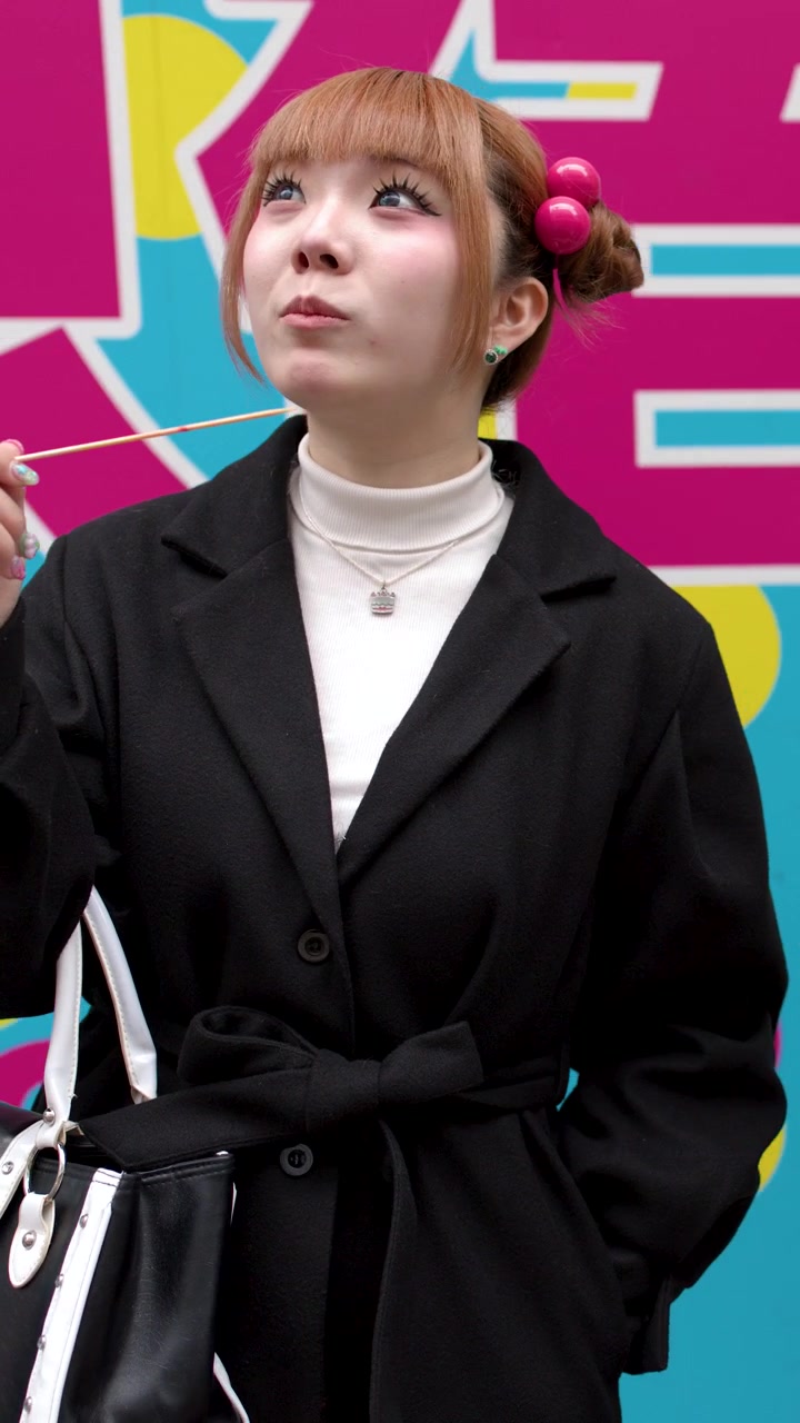 Giovane donna che mangia cibo da strada a Harajuku, Tokyo