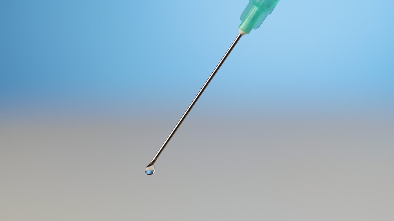 매우 가까운 의료 주사 바늘에서 진통제 액체가 흘러나오고 있습니다.