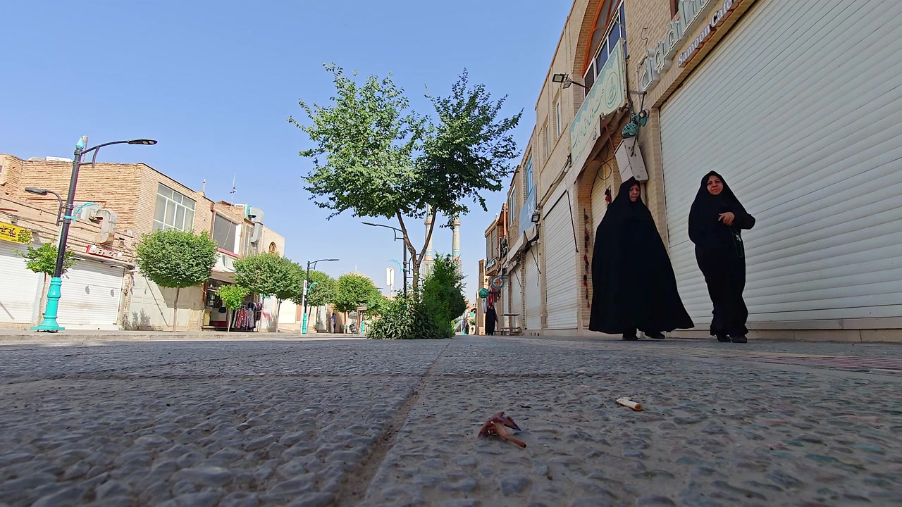 Dos mujeres con chadores negros caminando por una calle tranquila