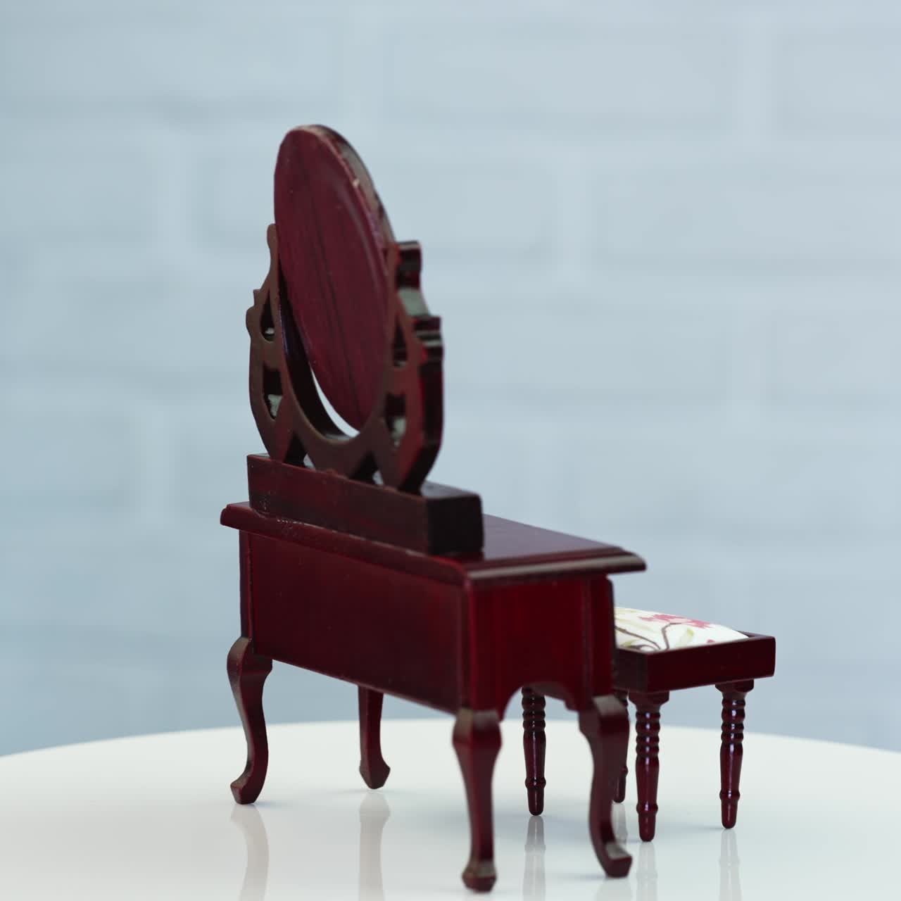 Beautiful wooden nightstand and little stool at the rotating table. Adorable pieces of furniture at white backdrop