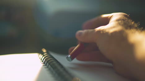 close up of a man's hand trying to write something, tapping the pen and then putting pen down