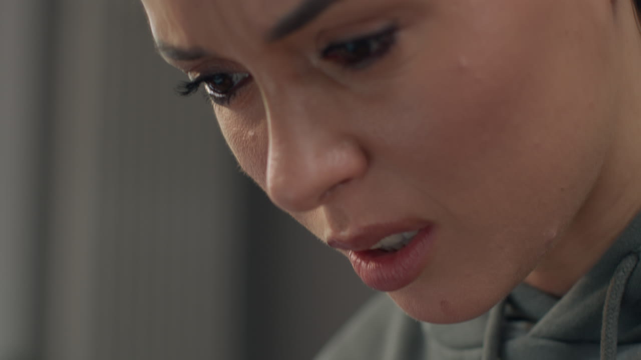 집 안에서 소파에 앉아서 노트북을 사용하고 생활비 위기에 대해 걱정하는 불안한 여성의 얼굴.