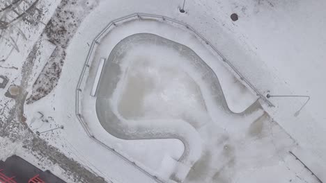 graue betonschüssel im skatepark mit etwas schnee bedeckt und für die nebensaison allein gelassen