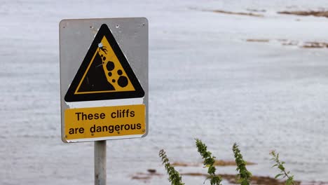 warning sign about dangerous cliffs in fife, scotland