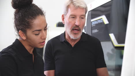 aprendizaje femenino trabajando con un ingeniero en máquinas cnc