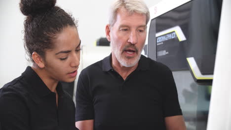 female apprentice working with engineer on cnc machinery