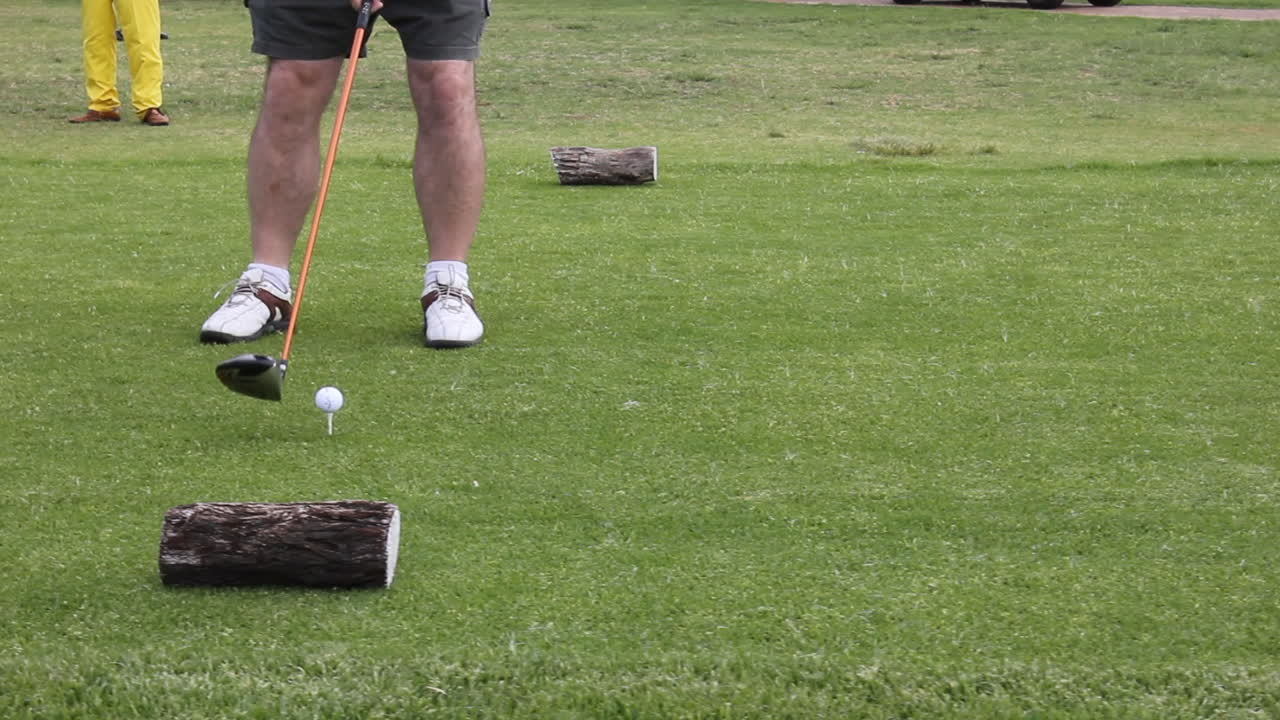 Man with golf shoes walking up to hit golf ball