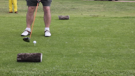 man with golf shoes walking up to hit golf ball