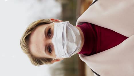 Beautiful-Caucasian-Female-Wearing-Medical-Mask-to-Protect-From-Covid19-Contamination-Young-Woman.Beautiful-Caucasian-female-wearing-medical-mask-to-protect-from-covid-19-contamination.-Young-woman-standing-on-street-and-looking-to-camera.-Virus,-pandemic,-safety-concept.