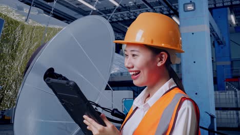 woman engineer inspecting industrial machinery with a tablet