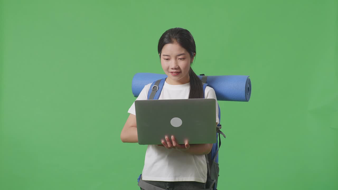 mujer con mochila usando portátil