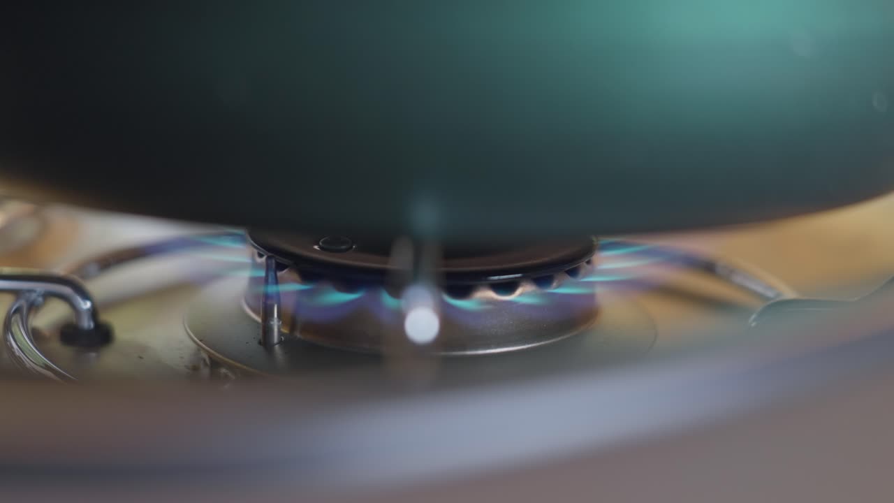 위에 비와 함께 가스 스토브 버너를 켜고 있습니다.