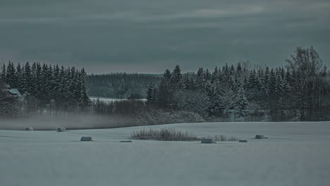 time lapse of sunrise in snow capped forest landscape wiith low fog