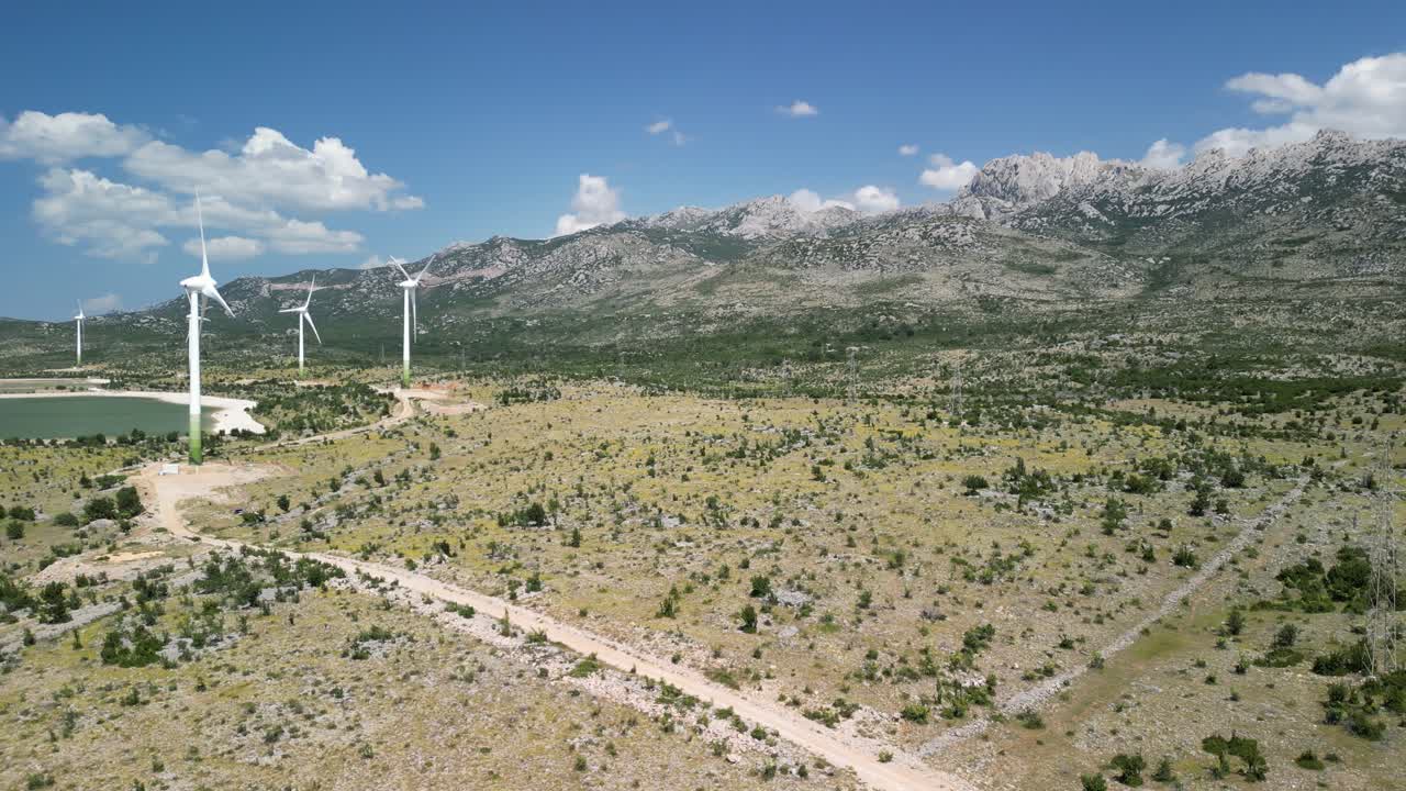 imágenes de drones sobre la región árida, la cordillera de velebit con turbinas eólicas girando y agua recogida en dos lagos, azul y verde
