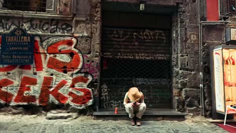 people pass by a graffiti-covered alleyway cafe