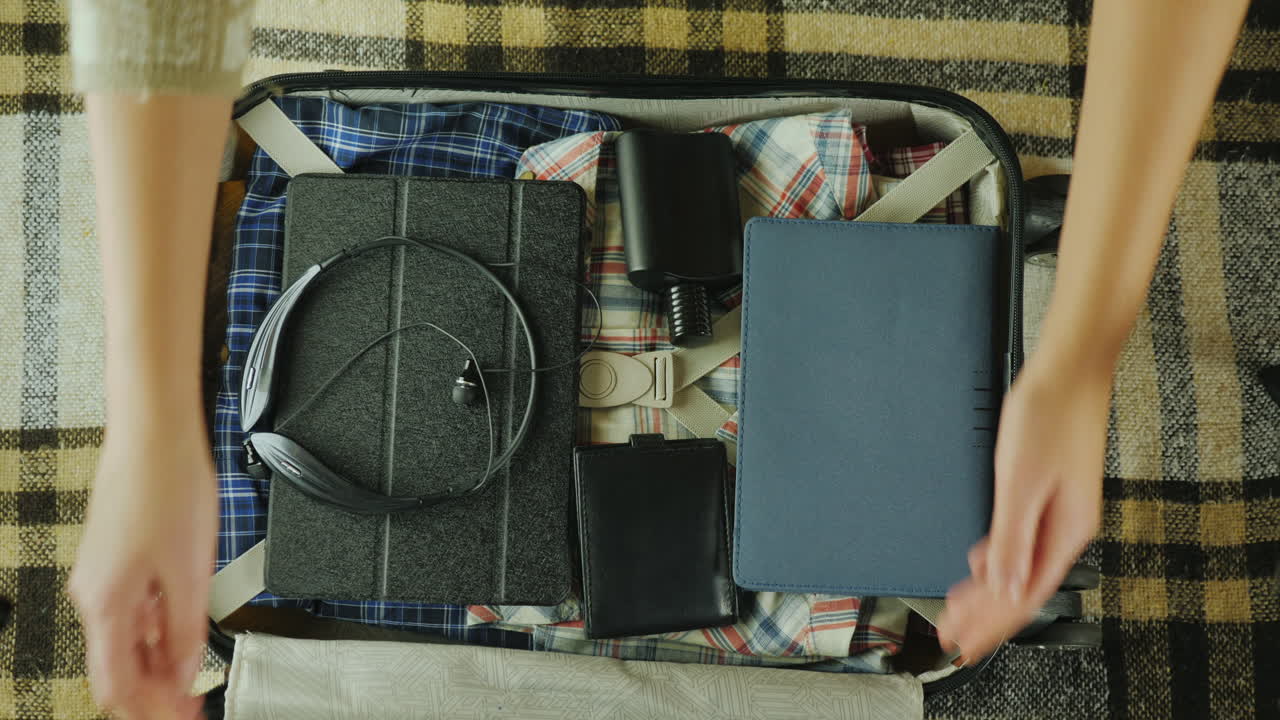 한 여성이 짐을 풀고 호텔 개념 4k vide에 도착한 여행 가방에서 물건을 꺼냅니다.