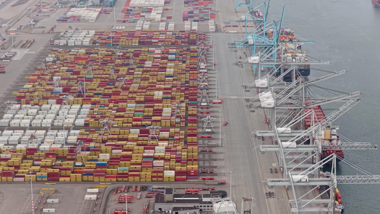 Commercial dock at Rotterdam port, cargo containers and cranes in action