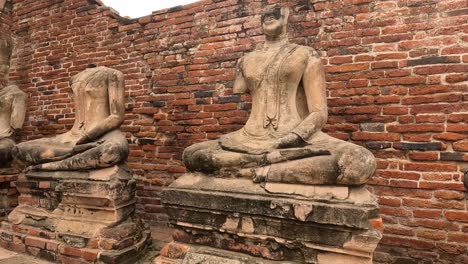 decapitated buddha statues at a brick temple ruin