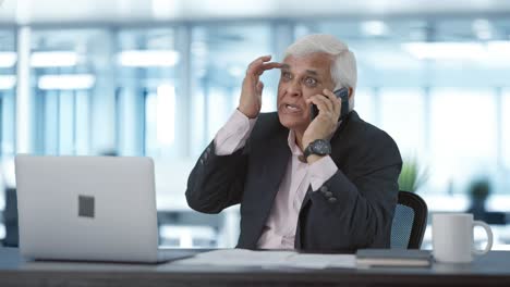 el gerente senior indio enojado gritando en el teléfono móvil
