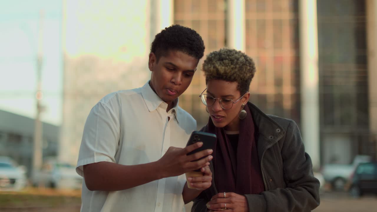 Friends exploring and communicating with a smartphone in an urban setting