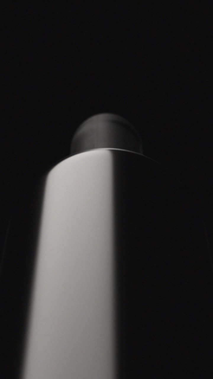 Dramatic Light Beam Shines on a White Product Bottle