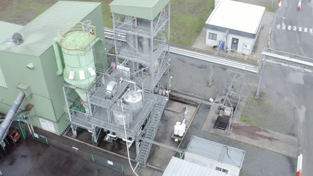 Aerial circling view of DRT industrial processing machinery, tanks, cyclone separator, worker visible, Veille-Saint-Girons, France