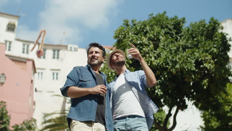 foto média do feliz casal gay parado na rua e se beijando