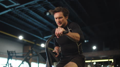 hombre deportivo sonriente haciendo ejercicio en el gimnasio. hombre de fitness haciendo cardio en el club deportivo