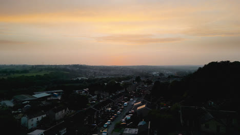 Experience-Heckmondwike,-UK,-through-captivating-drone-shot-aerial-footage,-highlighting-industrial-structures,-lively-streets,-and-the-historic-town-center-during-a-summer-evening