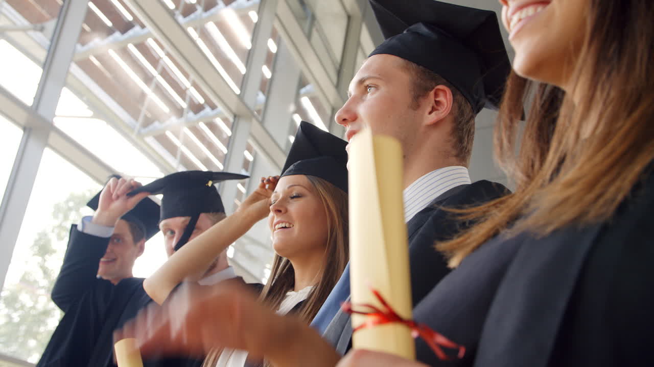 estudiantes en la ceremonia de graduación lanzando sombreros en el aire