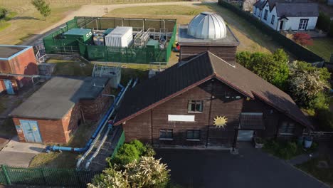 Aerial-view-Pex-hill-Leighton-observatory-silver-dome-rooftop-on-hilltop-farmland-at-sunrise,-low-orbit-left