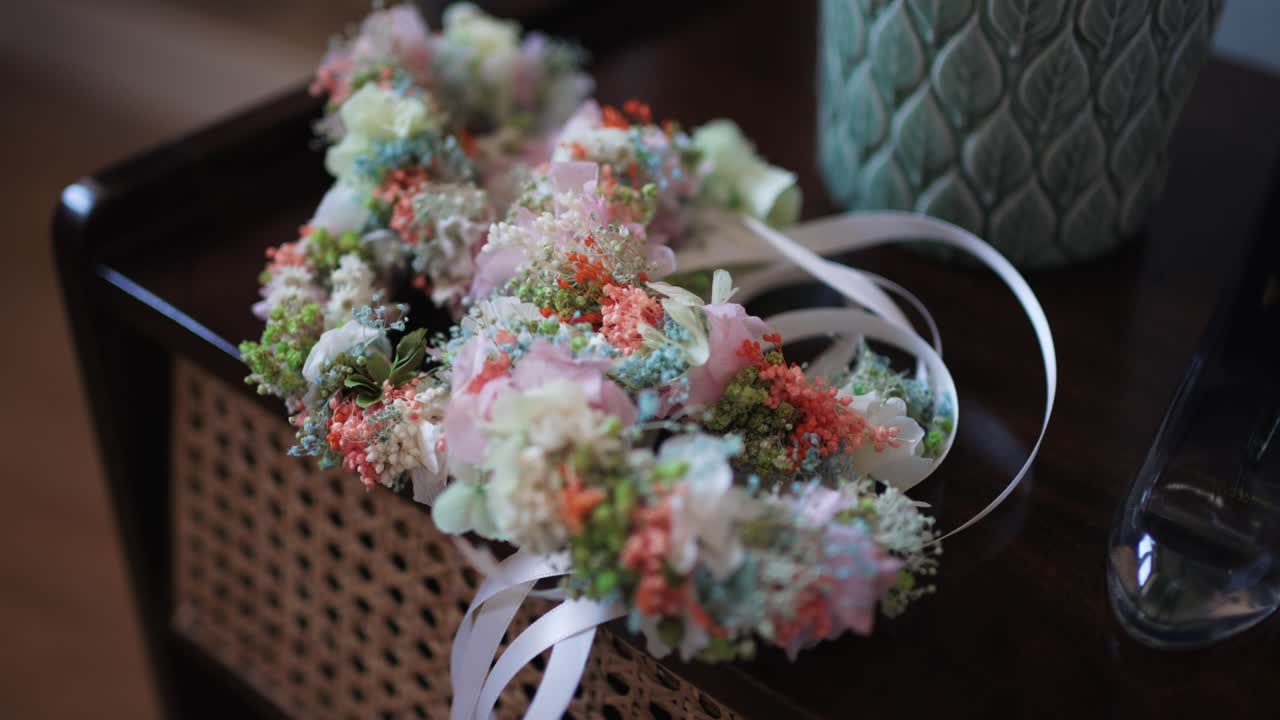 delicate floral wedding crown with pastel blooms and ribbons placed on a wooden table
