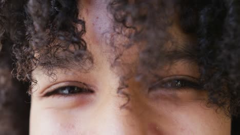 retrato de cerca de los ojos de una feliz adolescente afroamericana sonriendo, en cámara lenta