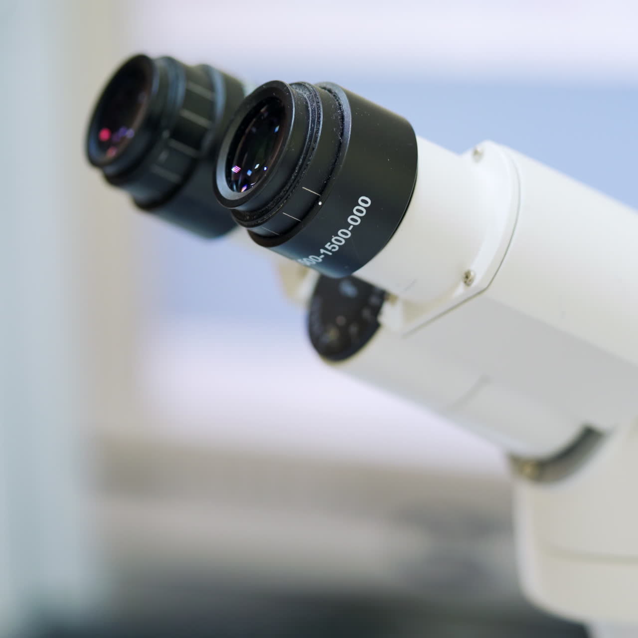 Woman at modern microscope. Close-up microscope in the laboratory. Medical assistant looking through the contemporary device. New technologies in medicine.