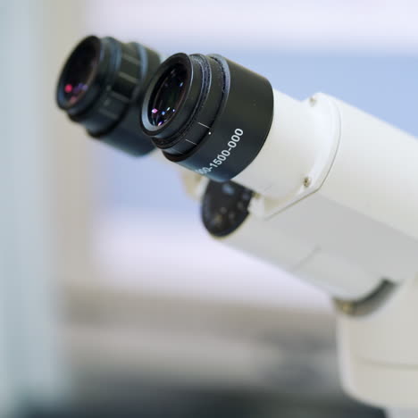 woman at modern microscope. close-up microscope in the laboratory. medical assistant looking through the contemporary device. new technologies in medicine.