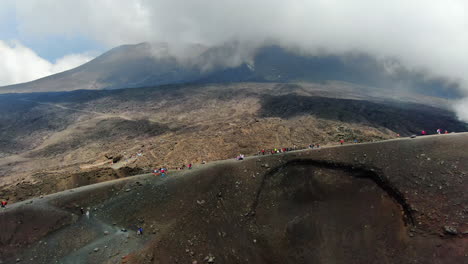 Dolly-Aéreo-En-Vista-Atmosférica-De-Personas-Haciendo-Senderismo-En-El-Volcán-Etna