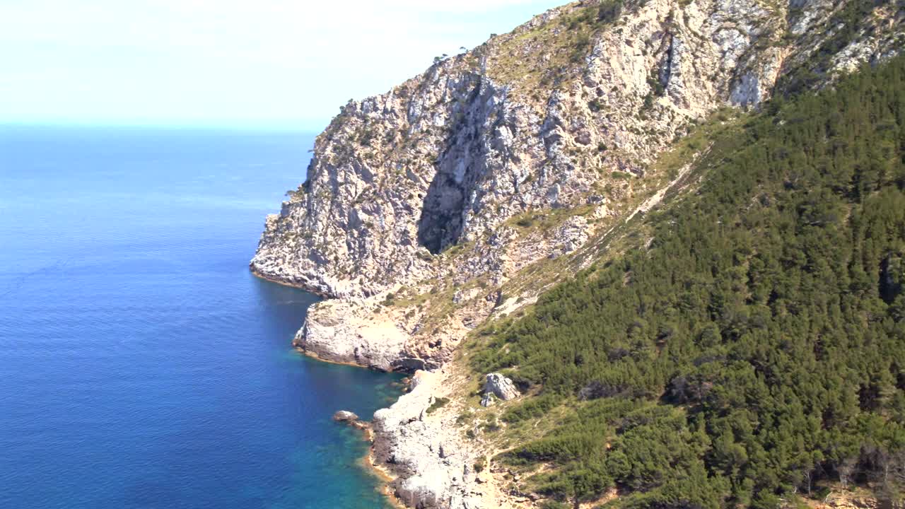 Beautiful coastal views of Coll Baix in Mallorca showcase clear blue waters and rocky cliffs. This serene spot invites visitors to relax and enjoy nature's wonders away from crowds.