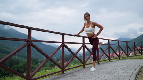mujer estirándose al aire libre en las montañas