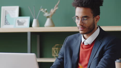 young professional working on laptop in modern office