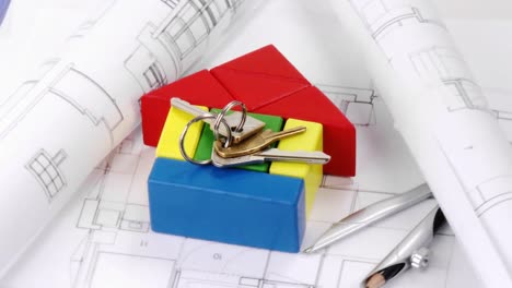 Close-up-of-plans,-model-house-and-keys-turning