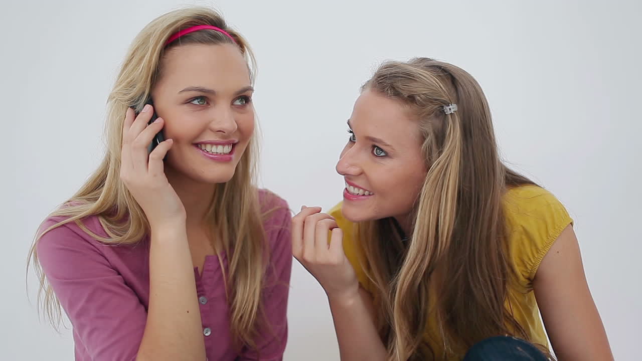 Smiling woman on the phone with her friends next to her