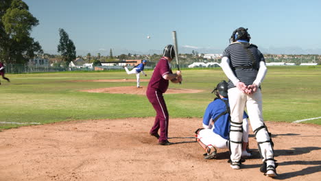 playing baseball, batter in maroon uniform preparing to hit pitch on field