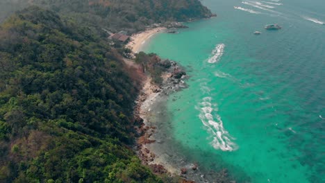 high-speed-boats-sail-along-narrow-sand-coastline-on-ocean